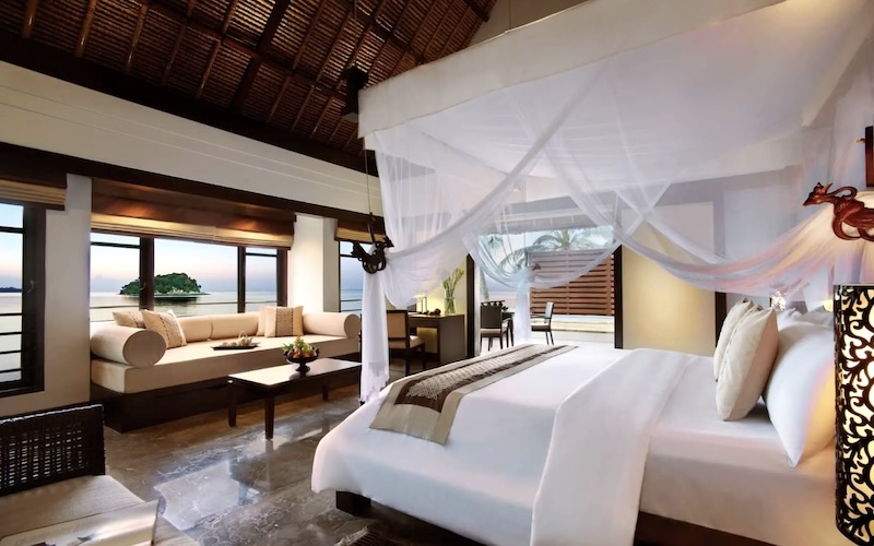 オーシャンフロントヴィラ｜窓辺のソファ越しに広がる海の景色